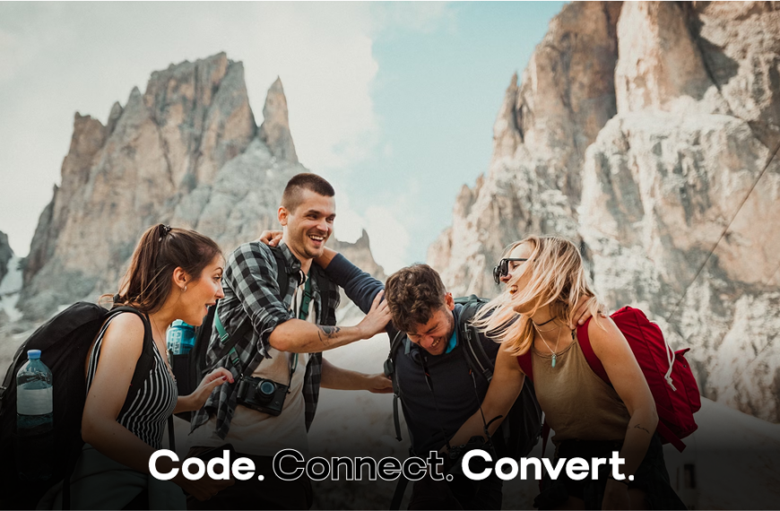 A group of four happy friends laugh together while hiking in a dramatic mountain setting, with a cable car visible in the background.