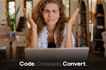 A woman with a confused and frustrated expression looks up from her laptop, holding her hands up in exasperation.