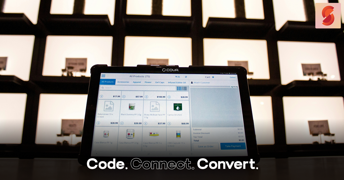 A tablet-based point-of-sale system on a counter displays a digital product catalog inside a modern retail store with backlit display shelves.