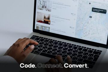 An over-the-shoulder view of a person's hands on a laptop keyboard, browsing a travel rental website that shows a list of properties and a city map.